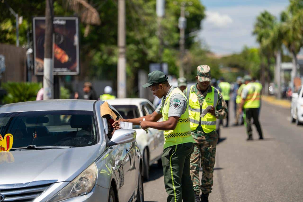 Agentes revisan un vehículo durante un operativo de fiscalización del transporte público en el Distrito Nacional.