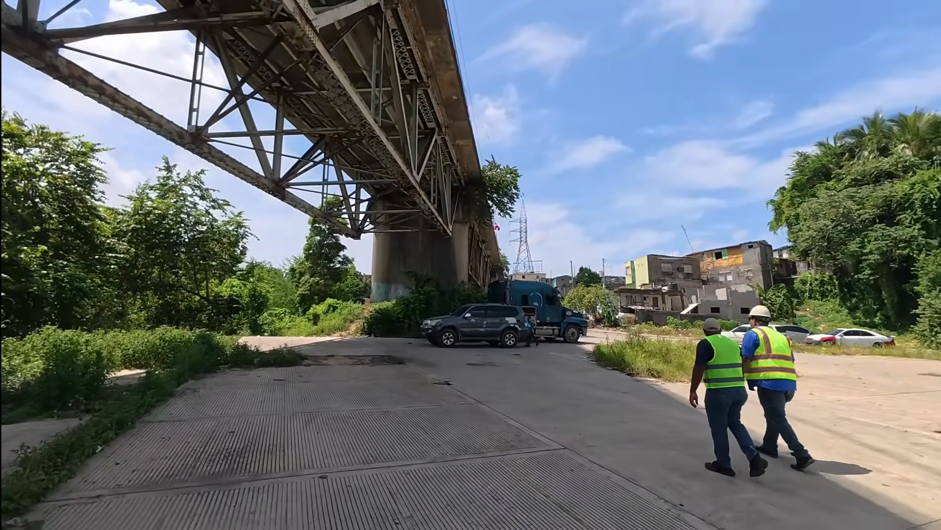 Participantes con cascos y chalecos recorren el entorno bajo el puente General Gregorio Luperón